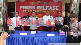 Polisi membawa barang bukti.